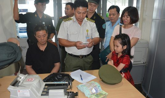 Du khách Trung Quốc Wang Qing Jian (ngồi, áo đen) bị tạm giữ tại phòng trực ban an ninh sân bay Đà Nẵng