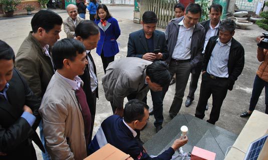 Cán bộ kỹ thuật của sở Công thương hướng dẫn bà con và cán bộ xã Đồng Nghê thao tác lắp đặt và sử dụng máy phát điện mặt trời Sola của công ty Vũ Phong trao tặng.