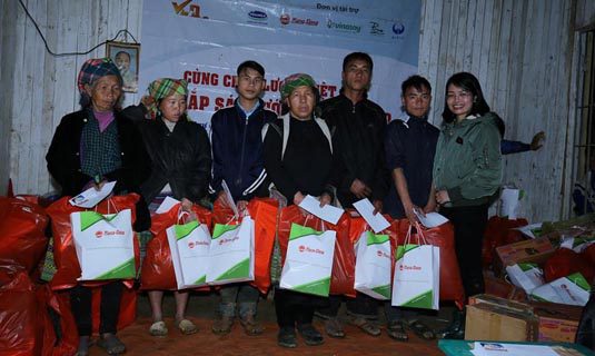 Đại diện Công ty Cổ phần Bóng đèn & Phích nước Rạng Đông trao quà cho người dân bản Cu Vai.