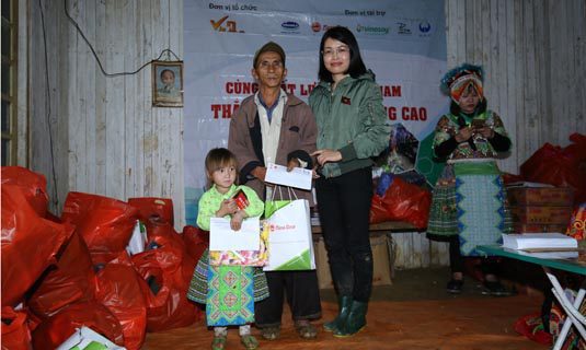 Đại diện Rạng Đông trao quà và tiền mặt hỗ trợ bé Mùa Thị Tòng và ông ngoại bé.