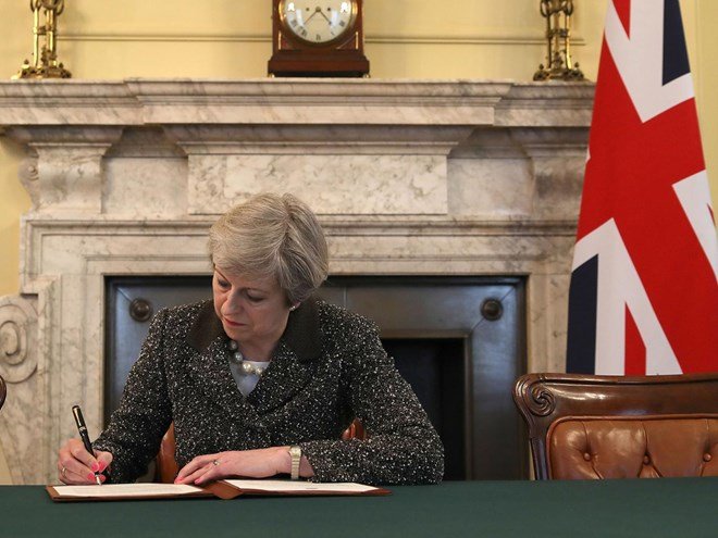 Thủ tướng Anh Theresa May ký bức thư gửi Chủ tịch EU. Nguồn ảnh: TTXVN/PA
