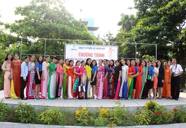 Cô Nguyễn Vân Khanh (áo vàng đứng giữa) và các thầy cô trường Tiểu học Vĩnh Hòa chụp hình lưu niệm cùng Đội tuyên truyền tiết kiệm điện PC Khánh Hòa