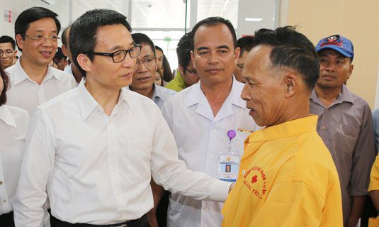 Phó Thủ tướng Vũ Đức Đam trò chuyện với người nhà bệnh nhân tại Bệnh viện đa khoa thị xã Quảng Yên, Quảng Ninh. Ảnh: VGP/Đình Nam