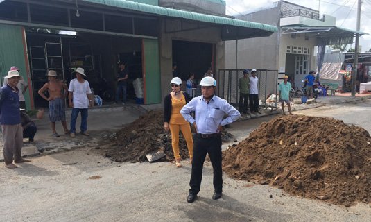 Ông Phan Ngọc Thanh (đứng chống nạnh) đổ đất ngăn đường vào chợ