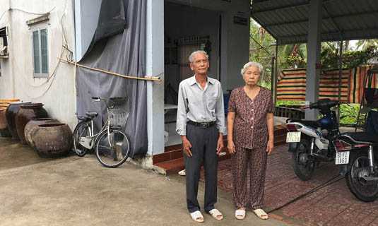 Vợ chồng ông Long trước căn nhà tình nghĩa.