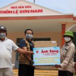 Nhà báo Đắc Bình Trưởng đại diện VPMT-TB trao khẩu trang cho Thôn trưởng Lê Sơn Nam Mai Hồng Lạc