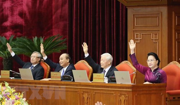Các đồng chí lãnh đạo Đảng, Nhà nước biểu quyết thông qua Nghị quyết Hội nghị. (Ảnh: Phương Hoa/TTXVN)